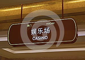 Sign hanging from ceiling showing Casino Gambling in bilingual Chinese and English, Macau, China