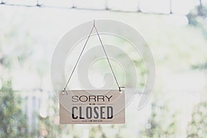 A sign hanging off Coffee shop door,Close sign blur background,Label word close