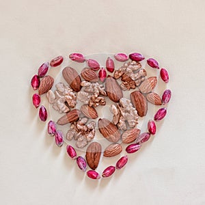 Sign heart lined with peeled pistachios, walnuts and almonds.