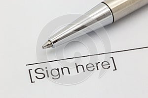 Sign here contract with a silver pen
