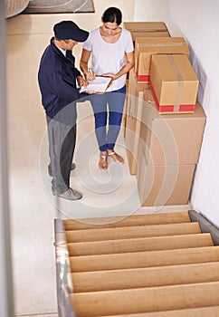 Sign here please..... A young woman receiving a package from a delivery man.