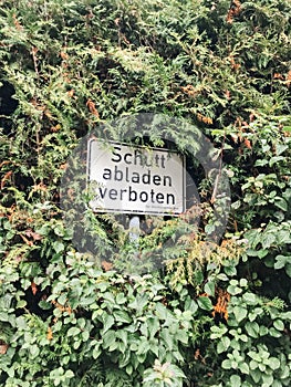 A sign is hidden behind a bush