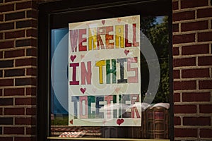 Sign hung in a shop window offering encouragement