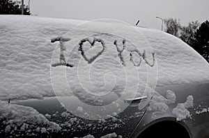 sign I love you on a parked snowy vehicle. one prank can mean divorce