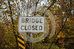 Sign indicating bridge ahead is closed. Selective focus, background and foreground blur.