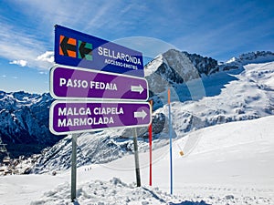 Sign indicating slopes and towns Passo Fedaia, Malga Ciapela, Marmolada and the access to the Sellaronda circuit, Dolomites, photo