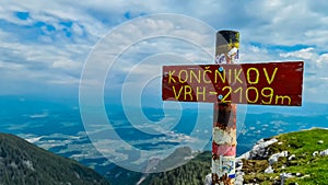 On top of mountain peak Kriznik, Carinthia, border Austria Slovenia. Alpine meadow with scenic view of mountain range Karawanks photo