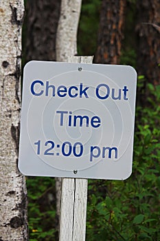 A sign indication check-out time is 12:00 pm