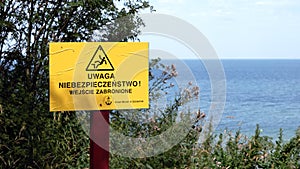 A sign informing about the danger and prohibiting entry in Polish on the beach of the Baltic Sea photo