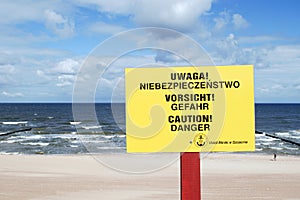 The sign informing about the danger in three languages - Polish, German and English. photo