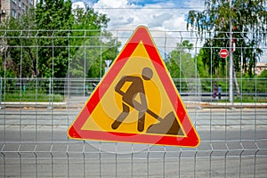 A sign informing about earthworks hangs on a metal fence