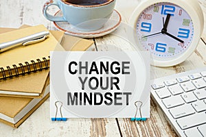 A sign with the inscription CHANGE YOUR MINDSET on the table