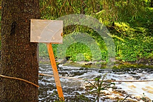 Sign for inscription in forest on background of river
