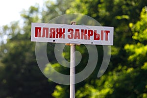 sign with the inscription in Russian the beach is closed