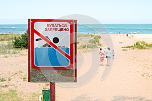 Sign with the inscription `Swimming is prohibited` written in Russian language