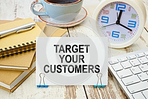 A sign with the inscription TARGET YOUR CUSTOMERS on the table