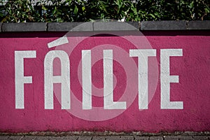 Sign in Irish language Failte welcome in English on a magenta color wall