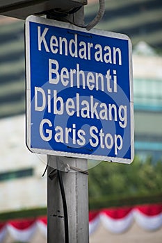 The sign of ``Kendaraan Berhenti Di Belakang Garis Stop`` means ``Vehicle Stops at behind of Stop Line``. photo