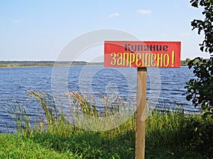 Sign in Lake Shore Water Saying in Russian Swimming Forbidden