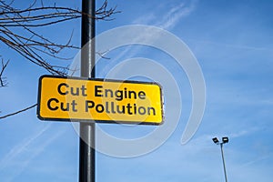 A sign on a lamppost reading cut engine cut pollution