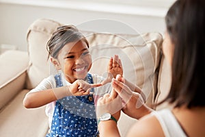 Sign language, learning and girl kid with her mother in the living room of their family home. Happy, smile and child
