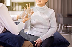 Sign language specialist talking with mature patient deaf hearing and showing hands gesture