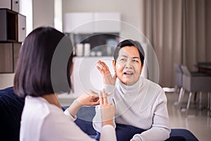 Sign language specialist talking with senior patient deaf hearing and showing hands gesture