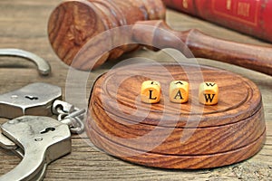 Sign LAW on the Soundboard, Judges Gavel, handcuffs and book in