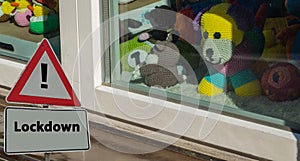 Sign Lockdown in Front of Kindergarten Window with Stuffed animals