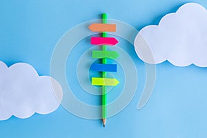Sign made of pencil and sticky notes with white clouds abstract