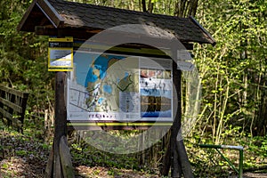 Sign with map of national park standing in the forest on sunny day