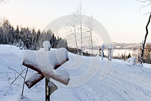 Sign marking a snowmobile trail in foreground and landscape in background