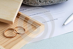 Sign of marriage contract form agreement with a pair of wedding rings