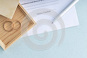 Sign of marriage contract form agreement with a pair of wedding rings