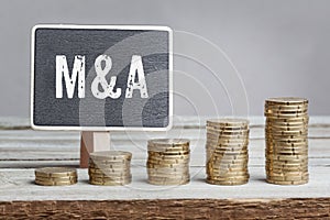 Sign Mergers and Acquisitions with growth coin stacks photo