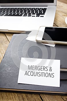Sign Mergers & Acquisitions on Office desktop with electronic de