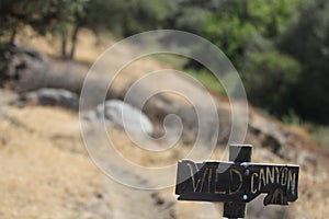 A sign on a mountain trail that reads Wild canyon