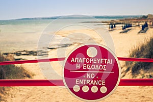 Sign No Entrance before the beach near of Ayia Napa and Cavo Greco, Cyprus island, Mediterranean Sea. Retro film simulation