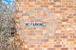 Sign no parking for drivers in the brick wall in England