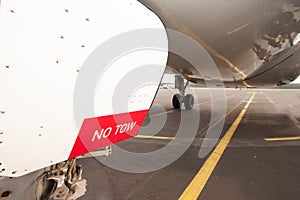 Sign NO TOW on undercarriage of airplane - jetplane waiting on r