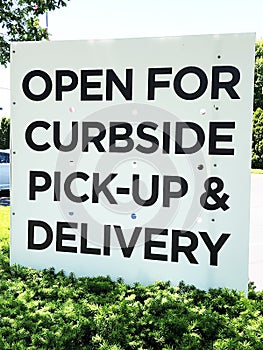 Sign `Open for curbside pick-up and delivery`