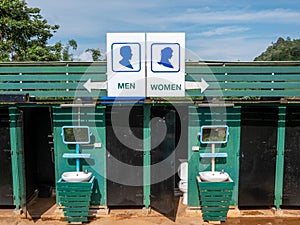 A sign outside public toilet in thailand with writing in English; Men and Women