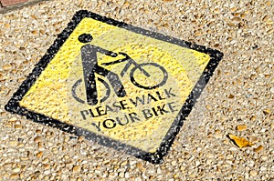 Please Walk your Bike Sign Painted on the Surface of a Sidewalk