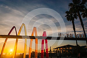 Sign and palm trees at sunset in Imperial Beach, California.