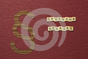 The sign paragraph on the claret color background. Word in german deutsche Gesetze