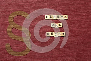 The sign paragraph on the claret color background. Word in german Gesetz und Recht