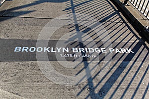Sign on pavement of Brooklyn Bridge with text: Brooklyn bridge Park