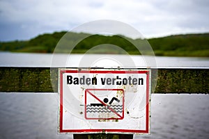 Sign with a pictogram that prohibits swimming. photo