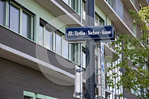 A sign on a pole with the name of the Lydia-Sicher-Gasse street in Vienna