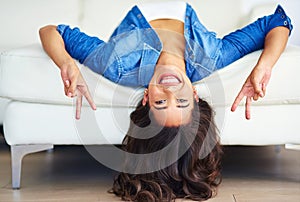 Sign, portrait and girl upside down with peace gesture with hands relaxing with freedom in house living room sofa. Smile